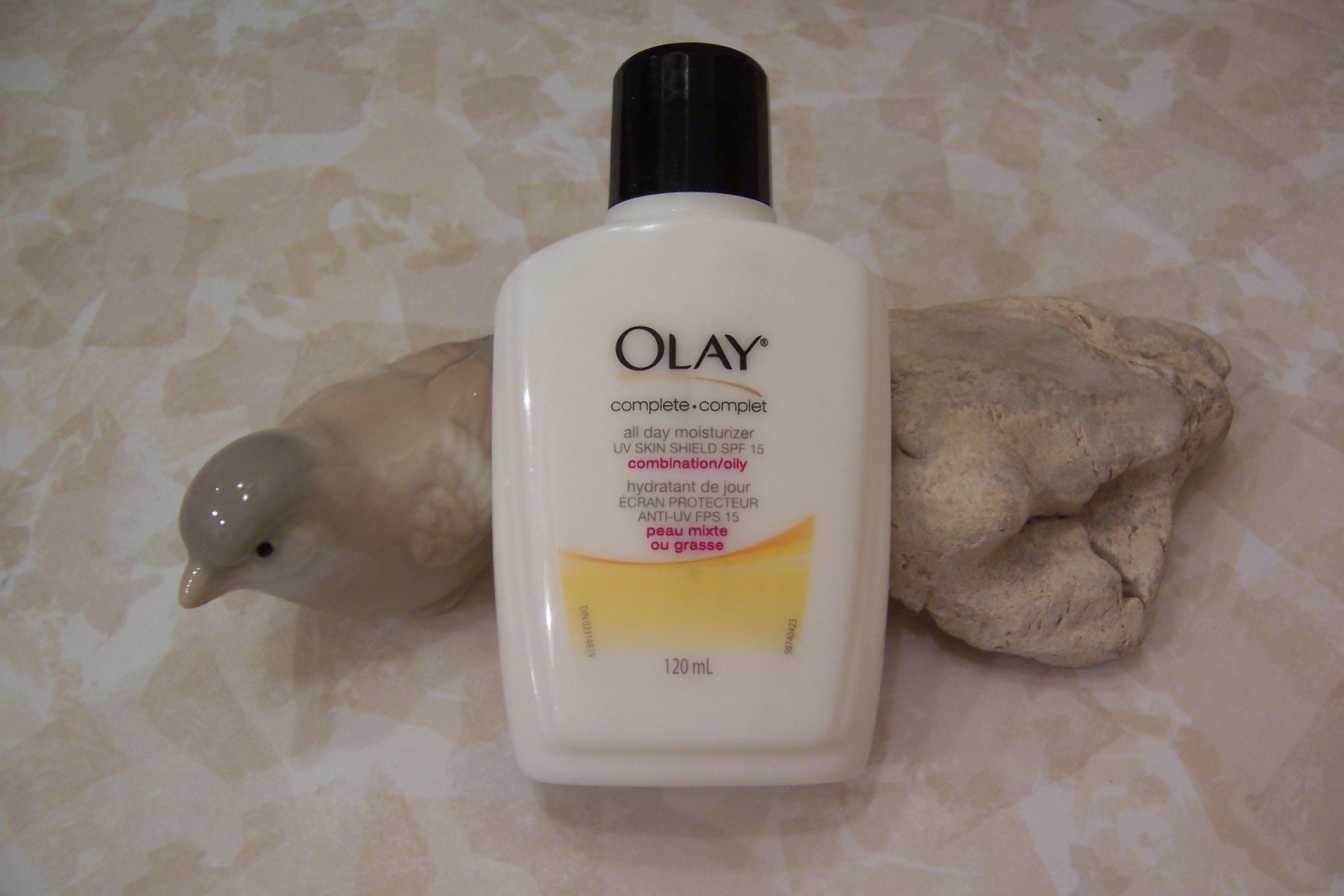 Olay Complete All Day Moisturizer in a white bottle with yellow label, daily face moisturizer with SPF 15 for normal skin, lightweight formula providing hydration and sun protection.